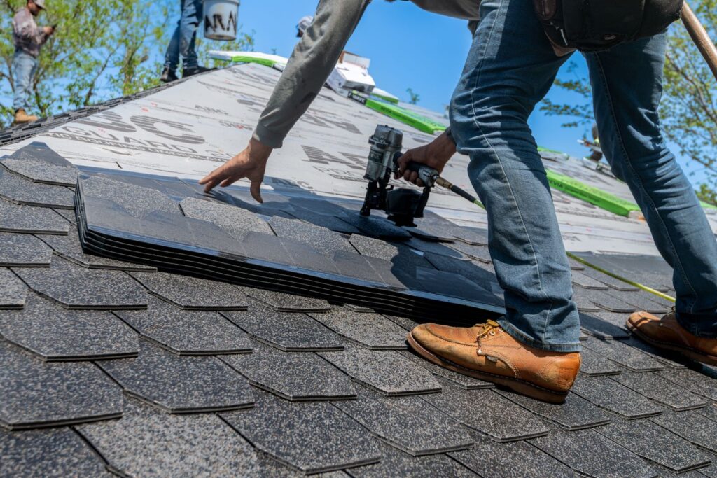 Roofers installing new asphalt shingles during a roof replacement in Mansfield, TX